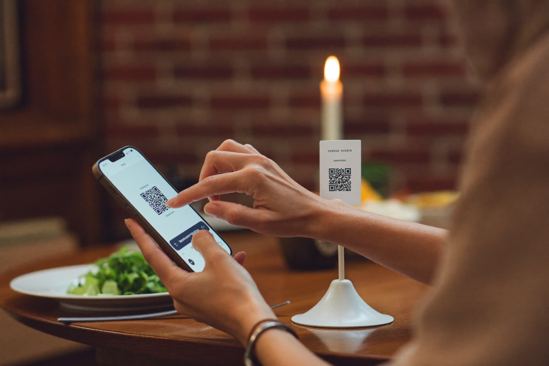 Guest scanning the Mentiaq QR code at a candlelit table